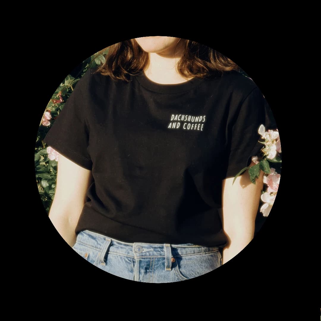 Model wearing a black Pet Shop Club t-shirt with a custom "Dachshunds and coffee" print